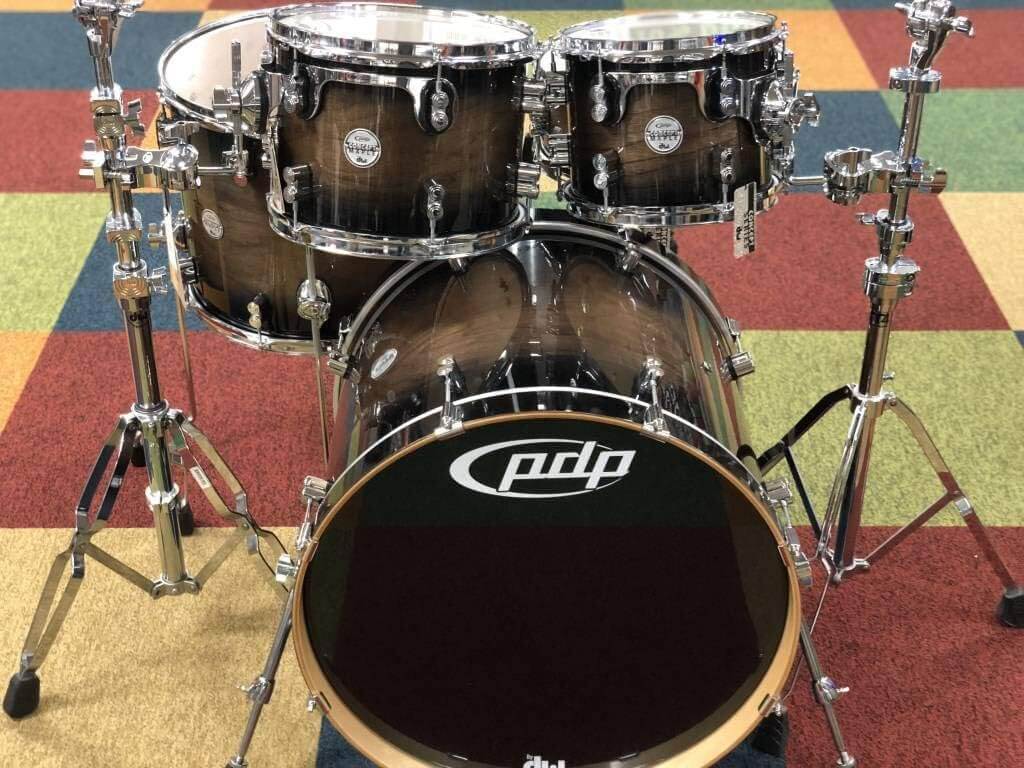 PDP Concept Exotic 5-Piece Shell Pack in Walnut and Charcoal Burst finish, showcasing the drum set's elegant design and craftsmanship.